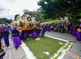 Hombres recorren las calles mientras llevan en hombros la imagen de Jesús de las Tres Potencias.