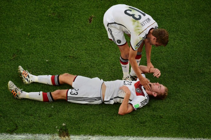 ARCHIVO - El jugador alemán Christoph Kramer tirado en el césped mientras recibe auxilio de su compañero Thomas Mueller durante la final contra Argentina en el Mundial, el 13 de julio de 2024, en Río de Janeiro. (AP Foto/Francois Xavier Marit, Pool)