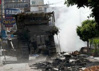 Excavadoras israelíes se mueven a través del humo durante los enfrentamientos del quinto día de una operación militar israelí en la ciudad de Jenin, en Cisjordania, 1 de septiembre de 2024. Foto La Hora / EFE