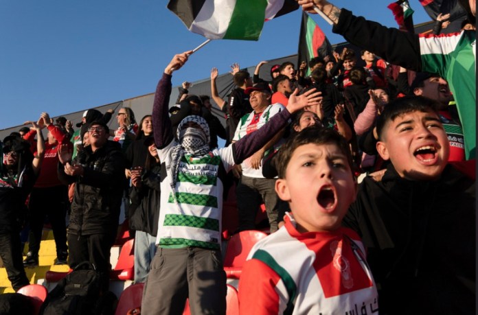 Hinchas de Club Palestino celebran su segundo gol contra Santiago Wanderers en un duelo de la liga local en el estadio La Cisterna en Santiago, Chile, el viernes 12 de julio de 2024. (AP Foto/Matias Basualdo)