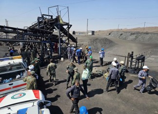 En esta foto publicada por la Sociedad de la Media Luna Roja Iraní, mineros y policías se ven junto a una mina de carbón donde una fuga de metano provocó una explosión el sábado en Tabas, unos 540 kilómetros (335 millas) al sureste de la capital, Teherán, Irán, el domingo 22 de septiembre de 2024. (Sociedad de la Media Luna Roja Iraní, via AP)