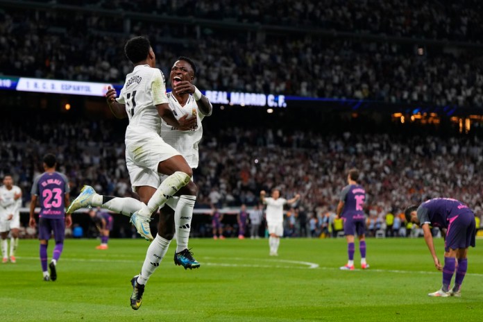 Rodrygo celebra con su compañero del Real Madrid, Vinícius Júnior tras anotar el tercer gol de su equipo en el encuentro ante el Espanyol en la liga española el sábado 21 de septiembre del 2024. (AP Foto/Manu Fernandez)