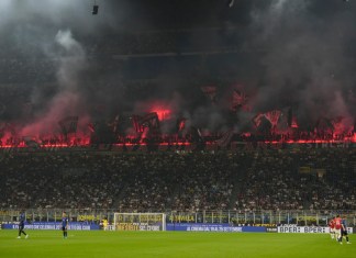 Hinchas del AC Milan encienden bengalas tras el gol de Christian Pulisic en el partido contra el Inter en el estadio San Siro de Milán, el domingo 22 de septiembre de 2024. (AP Foto/Luca Bruno)