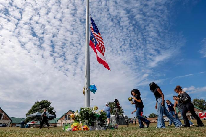 Los dolientes hacen una pausa en un monumento improvisado, un día después del tiroteo mortal en la escuela secundaria Apalachee en Winder, Georgia, EE. UU., el 5 de septiembre de 2024. EFE/EPA/Erik S. Lesser