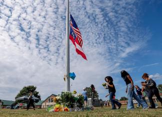Los dolientes hacen una pausa en un monumento improvisado, un día después del tiroteo mortal en la escuela secundaria Apalachee en Winder, Georgia, EE. UU., el 5 de septiembre de 2024. EFE/EPA/Erik S. Lesser