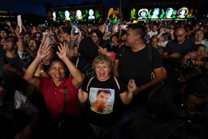 Fans de Juan Gabriel cantan durante una proyección de uno de sus conciertos en el Zócalo, la plaza principal de la Ciudad de México, el domingo 22 de septiembre de 2024. (Foto AP/Fernando Llano)