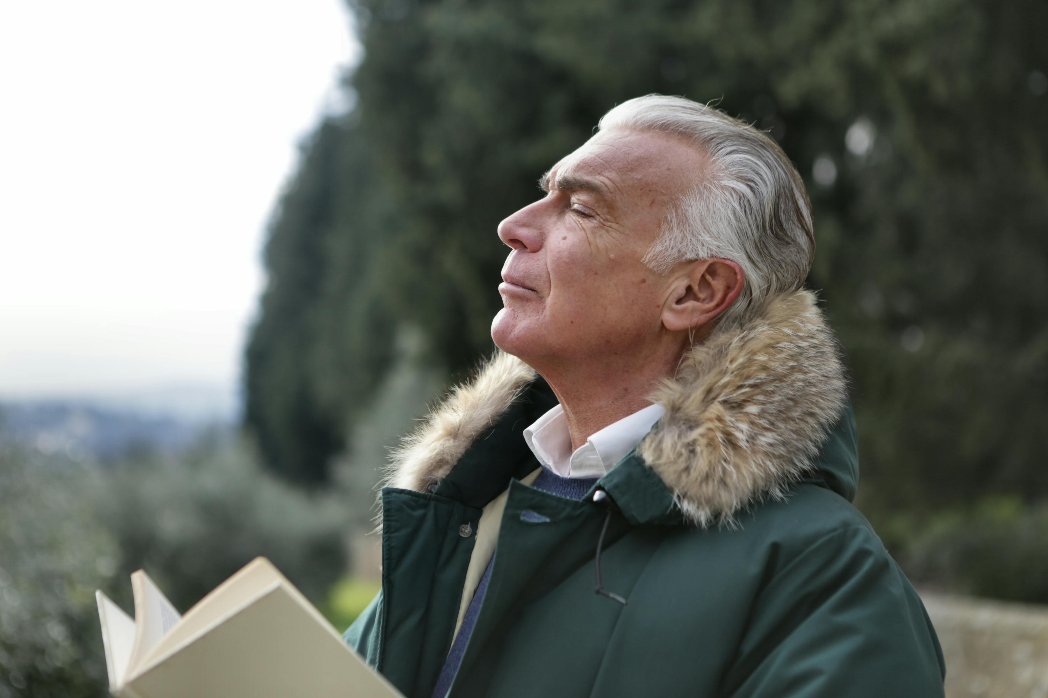 Hombre mayor de edad respirando en el aire libre