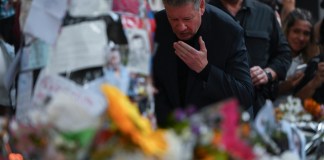 Geoff Payne, a la derecha, padre del exintegrante de One Direction, el cantante Liam Payne, visita un altar improvisado fuera del hotel Casa Sur Hotel donde el artista pop británico murió al precipitarse desde un balcón, en Buenos Aires, Argentina, el viernes 18 de octubre de 2024. (AP Foto/Mario de Fina)