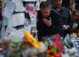 Geoff Payne, a la derecha, padre del exintegrante de One Direction, el cantante Liam Payne, visita un altar improvisado fuera del hotel Casa Sur Hotel donde el artista pop británico murió al precipitarse desde un balcón, en Buenos Aires, Argentina, el viernes 18 de octubre de 2024. (AP Foto/Mario de Fina)