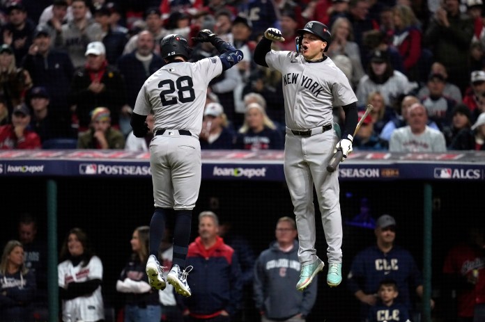 New York Yankees' Austin Wells (28) celebrates with Alex Verdugo after hitting a home run against the Cleveland Guardians during the second inning in Game 4 of the baseball AL Championship Series Friday, Oct. 18, 2024, in Cleveland. (AP Photo/Sue Ogrocki)