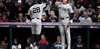 New York Yankees' Austin Wells (28) celebrates with Alex Verdugo after hitting a home run against the Cleveland Guardians during the second inning in Game 4 of the baseball AL Championship Series Friday, Oct. 18, 2024, in Cleveland. (AP Photo/Sue Ogrocki)