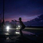 Una mujer se prepara para agarrar un frisbee durante el apagón masivo en el que derivó la caída en el funcionamiento de una de las mayores plantas termoeléctricas del país, en La Habana, Cuba, el viernes 18 de octubre de 2024. (AP Foto/Ramón Espinosa)