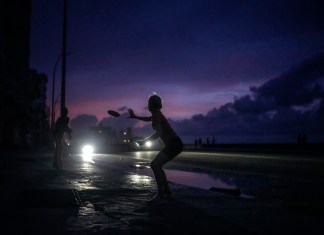 Una mujer se prepara para agarrar un frisbee durante el apagón masivo en el que derivó la caída en el funcionamiento de una de las mayores plantas termoeléctricas del país, en La Habana, Cuba, el viernes 18 de octubre de 2024. (AP Foto/Ramón Espinosa)