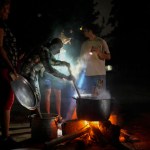 Personas preparan una sopa en una fogata durante un apagón que siguió a la falla de una importante planta energética en La Habana, Cuba, el sábado 19 de octubre de 2024. (AP Foto/Ramón Espinosa)