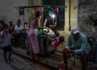 Una mujer compra sopa a un vendedor ambulante durante un corte de energía en La Habana, Cuba, el lunes 21 de octubre de 2024. (AP Foto/Ramón Espinosa)