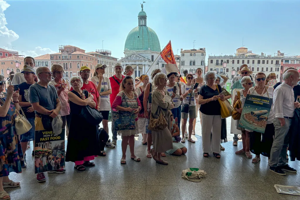 ARCHIVO - Activistas se congregan afuera de la estación de trenes de Santa Lucía, en Venecia, el 13 de julio de 2024, para protestar contra la tarifa para visitantes de un día. (AP Foto/Colleen Barry, archivo)