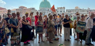 ARCHIVO - Activistas se congregan afuera de la estación de trenes de Santa Lucía, en Venecia, el 13 de julio de 2024, para protestar contra la tarifa para visitantes de un día. (AP Foto/Colleen Barry, archivo)