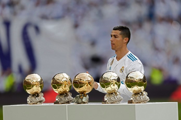 ARCHIVO - Foto del 9 de diciembre del 2017, el jugador del Real Madrid Cristiano Ronaldo posa con los cinco Balones de Oro que ha ganado. (AP Foto/Francisco Seco)