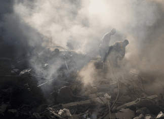 Recatistas buscan posibles víctimas entre los restos de un ataque israelí en la víspera, en Beirut, Líbano, el 11 de octubre de 2024. (AP Foto/Hassan Ammar)