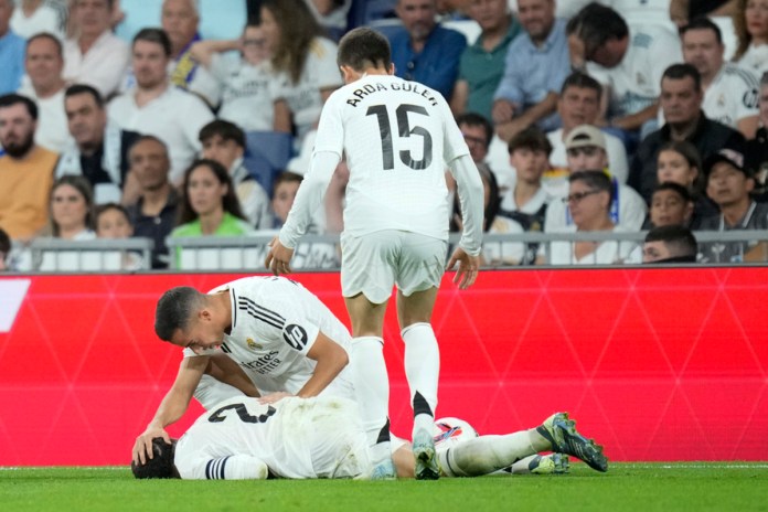 Lucas Vázquez trata de averiguar la condición de su compañero del Real Madrid, Dani Carvajal, quien se lastimó en el partido de La Liga ante el Villarreal, el sábado 5 de octubre de 2024. (AP Foto/Bernat Armangue)