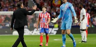 El portero del Real Madrid Thibaut Courtois (d) conversa con el entrenador del Atlético, Diego Simeone (i), durante el partido de la LaLiga EA Sports que Atlético de Madrid y Real Madrid en el estadio Civitas Metropolitano. EFE/Ballesteros