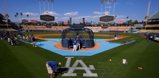 Un miembro del equipo de jardinería de los Dodgers de Los Ángeles pinta un logotipo en el campo antes de la práctica en preparación para el Juego 1 de una Serie Divisional de la Liga Nacional contra los Padres de San Diego, el jueves 3 de octubre de 2024, en Los Ángeles. (AP Foto/Mark J. Terrill)