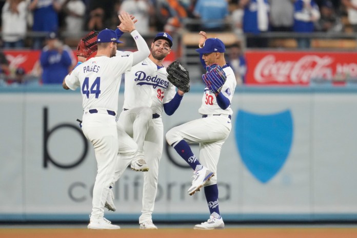 Los jardineros de los Dodgers de Los Ángeles, Andy Pages, Kevin Kiermaier y Mookie Betts, celebran su victoria contra los Mets de Nueva York en el Juego 1 de una Serie de Campeonato de la Liga Nacional de béisbol, el domingo 13 de octubre de 2024, en Los Ángeles. (AP Foto/Ashley Landis)