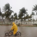 Una persona monta su bicicleta a través de una calle inundada mientras el huracán Milton, en México. (AP Foto/Martin Zetina)