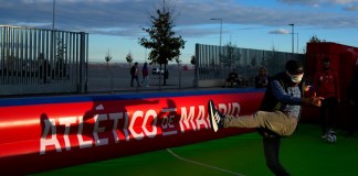 Un aficionado trata de patear a ciegas un balón antes del partido de la Liga de Campeones entre el Atlético de Madrid y el Lille en el Estadio Metropolitano, el miércoles 23 de octubre de 2024 (AP Foto/Manu Fernández)