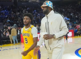 El escolta de los Lakers de Los Ángeles, Bronny James (9), sale de la cancha con LeBron James durante el medio tiempo de un partido de baloncesto de pretemporada de la NBA contra los Warriors de Golden State en San Francisco, el viernes 18 de octubre de 2024. (AP Foto/Jeff Chiu)