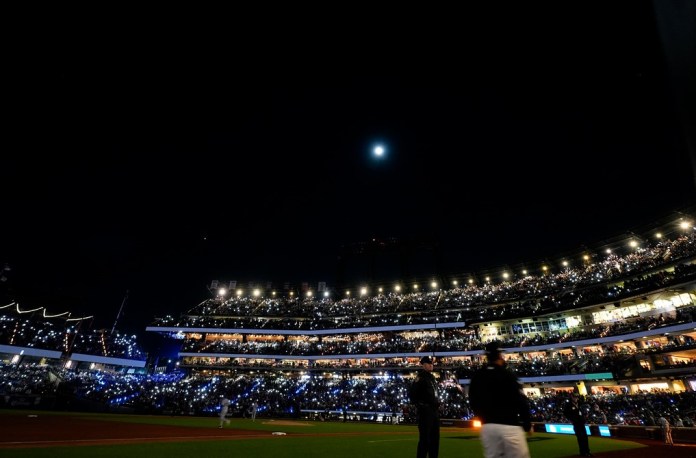 Aficionados encienden las luces LED en el estadio durante la tercera entrada del tercer juego de la Serie de Campeonato de la Liga Nacional ante los Dodgers de Los Ángeles el miércoles 16 de octubre del 2024. (AP Foto/Frank Franklin II)