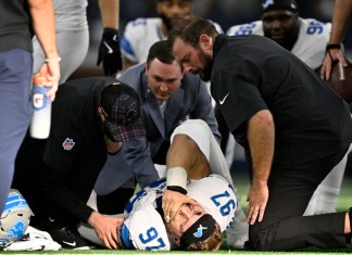 Aidan Hutchinson (97), defensive end de los Lions de Detroit, es atendido por el personal médico del equipo después de sufrir una lesión, aparentemente una fractura, durante la segunda mitad del juego de la NFL en contra de los Cowboys de Dallas, el domingo 13 de octubre de 2024, en Arlington, Texas. (AP Foto/Jerome Miron)