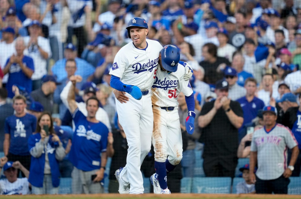 Freddie Freeman (izquierda) y Mookie Betts, de los Dodgers de Los Ángeles, festejan tras anotar en un sencillo durante el primer juego de la Serie de Campeonato de la Liga Nacional ante los Mets de Nueva York, el domingo 13 de octubre de 2024 (AP Foto/Ashley Landis)