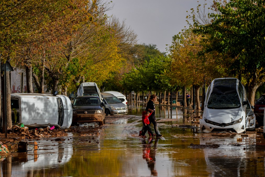 Personas cruzan la calle después de la inundaciones en Utiel, España. el miércoles 30 de octubre del 2024. (AP Foto/Manu Fernandez)