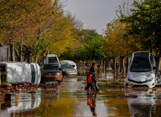 Personas cruzan la calle después de la inundaciones en Utiel, España. el miércoles 30 de octubre del 2024. (AP Foto/Manu Fernandez)