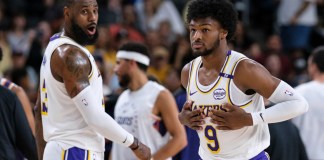 Bronny James (9), derecha, de los Lakers de Los Ángeles, entra a la cancha con su padre LeBron James (23), durante la primera mitad de un partido de pretemporada de baloncesto de la NBA el domingo 6 de octubre de 2024, en Palm Desert, California (Foto AP/William Liang)