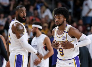 Bronny James (9), derecha, de los Lakers de Los Ángeles, entra a la cancha con su padre LeBron James (23), durante la primera mitad de un partido de pretemporada de baloncesto de la NBA el domingo 6 de octubre de 2024, en Palm Desert, California (Foto AP/William Liang)