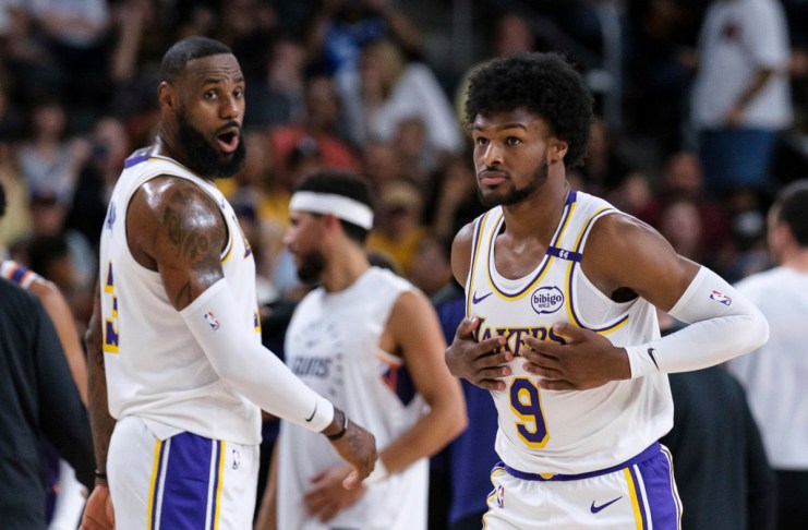 Bronny James (9), derecha, de los Lakers de Los Ángeles, entra a la cancha con su padre LeBron James (23), durante la primera mitad de un partido de pretemporada de baloncesto de la NBA el domingo 6 de octubre de 2024, en Palm Desert, California (Foto AP/William Liang)