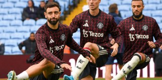 Bruno Fernandes, del Manchester United, a la izquierda, Jonny Evans, del Manchester United, en el centro, y Noussair Mazraoui, del Manchester United, se estiran durante un calentamiento antes del partido de fútbol de la Liga Premier inglesa entre Aston Villa y Manchester United, en Villa Park en Birmingham, Inglaterra, el domingo 6 de octubre de 2024. (Foto AP/Rui Vieira)