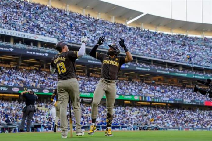 El jardinero de los Padres de San Diego Fernando Tatis Jr. (D) reacciona con el tercera base de los Padres de San Diego Manny Machado (I) luego de que Tatis conectara un jonrón solitario contra los Dodgers de Los Ángeles en la primera entrada del segundo juego de playoffs de la Serie Divisional de la Liga Nacional de Grandes Ligas (MLB) entre los Padres de San Diego y los Dodgers de Los Ángeles en Los Ángeles, California, EE. UU., 06 de octubre de 2024. La serie es al mejor de cinco juegos. EFE/EPA/ALLISON DINNER