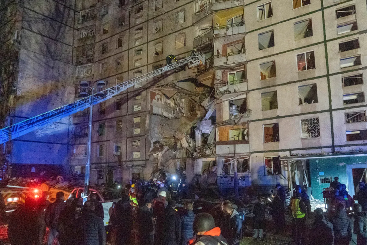 Rescatistas ayudan a la gente después de que un edificio de apartamentos de varias plantas fuera alcanzado por un ataque ruso en Járkiv, Ucrania, la noche del miércoles 30 de octubre de 2024. (AP Foto/Andrii Marienko)