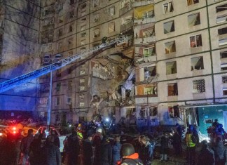 Rescatistas ayudan a la gente después de que un edificio de apartamentos de varias plantas fuera alcanzado por un ataque ruso en Járkiv, Ucrania, la noche del miércoles 30 de octubre de 2024. (AP Foto/Andrii Marienko)