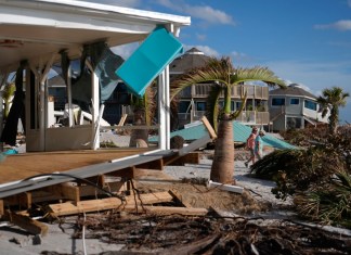 Kery Flynn, a la derecha, y su amigo caminan frente a una casa dañada con el techo destruido tras el paso del huracán Milton, el 13 de octubre de 2024, en Manasota Key, en Englewood, Florida. (AP Foto/Rebecca Blackwell, Archivo)