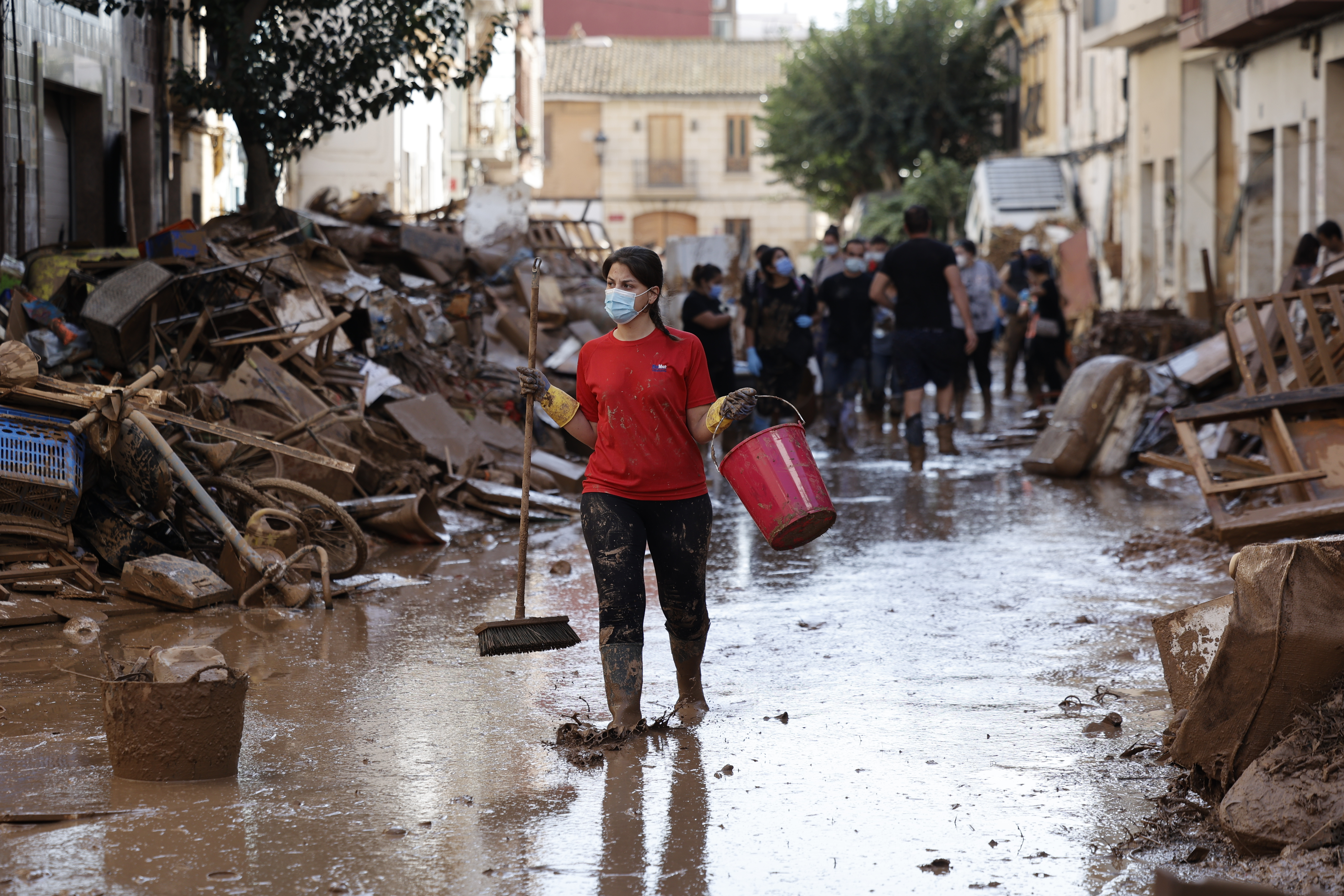 Por tercer día consecutivo una marea de voluntarios ha llegado este sábado a barrios del sur de la ciudad de Valencia asolados por la dana para luchar contra un fango, donde grupos especializados de los equipos de intervención buscan cadáveres en garajes o fosos aún anegados. Foto La Hora: EFE/ Biel Alino