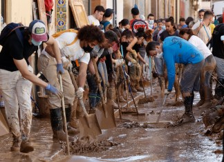 Varias personas retiran el lodo acumulado en una calle de la localidad valenciana de Paiporta, este sábado. Foto La Hora: EFE/ Biel Aliño