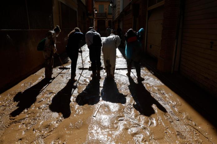 Voluntarios limpian este domingo el barro de una calle de la localidad española de Paiporta. Foto: La Hora - EFE/ Jorge Zapata.