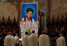 Una imagen de Carlo Acutis, un joven italiano de 15 años que murió en 2006 de leucemia, es descubierta durante su ceremonia de beatificación celebrada por el cardenal Agostino Vallini en la Basílica de San Francisco, en Asís, Italia, el sábado 10 de octubre de 2020.