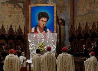 Una imagen de Carlo Acutis, un joven italiano de 15 años que murió en 2006 de leucemia, es descubierta durante su ceremonia de beatificación celebrada por el cardenal Agostino Vallini en la Basílica de San Francisco, en Asís, Italia, el sábado 10 de octubre de 2020.