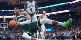 Giannis Antetokounmpo, de los Bucks de Milwaukee, cae a la duela frente a Jrue Holiday, de los Celtics de Boston, durante la segunda mitad del juego de baloncesto de la NBA, el domingo 10 de noviembre de 2024, en Milwaukee. (AP Foto/Morry Gash)