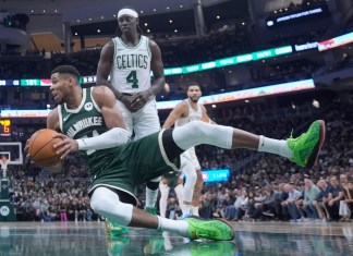 Giannis Antetokounmpo, de los Bucks de Milwaukee, cae a la duela frente a Jrue Holiday, de los Celtics de Boston, durante la segunda mitad del juego de baloncesto de la NBA, el domingo 10 de noviembre de 2024, en Milwaukee. (AP Foto/Morry Gash)